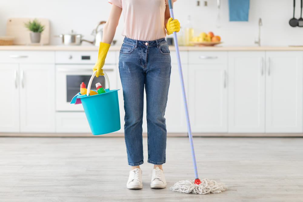 persoana cu galeata si mop in mana