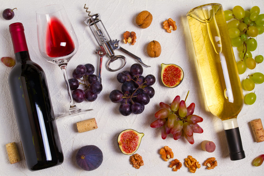 sticle de vin alb si rosu langa smochine si nuci