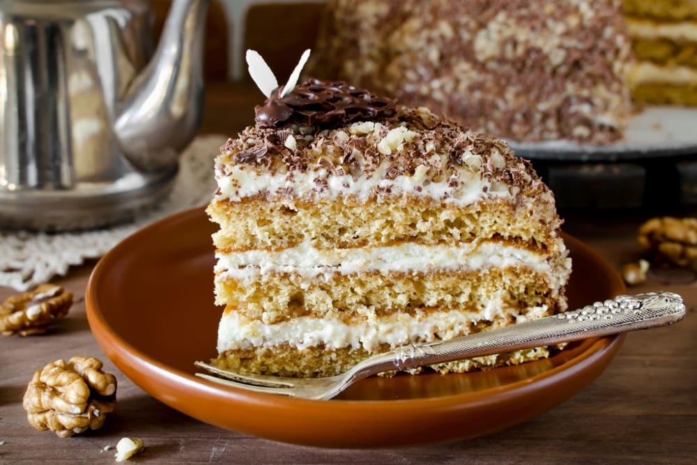 Bucata de prajitura cu nuca si mascarpone in farfurie ceramica