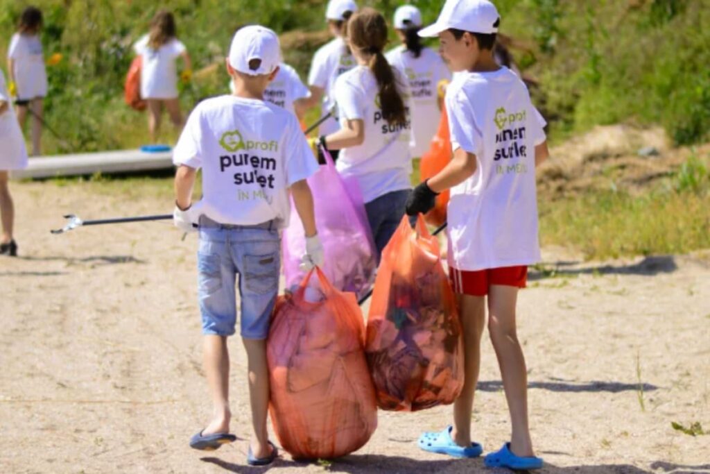Proiect de mediu sustinut de Profi Romania cu copii care aduna deseuri de pe plaja