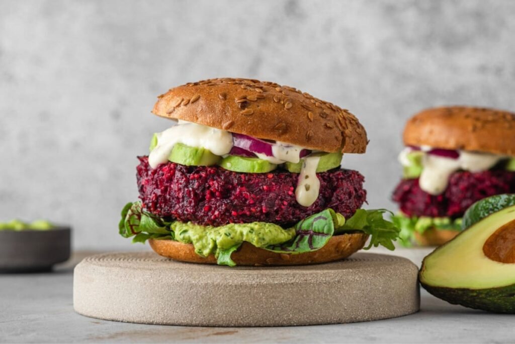 Burger vegetarian cu maioneza, avocado si ceapa pe blat ceramic