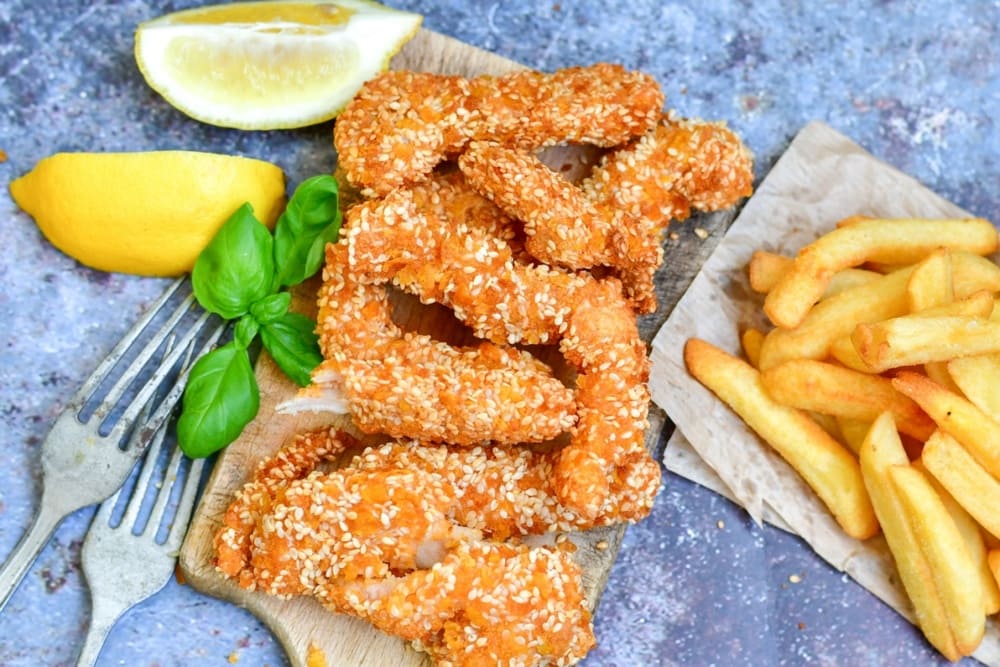 Pui Shanghai pe tocator din lemn langa cartofi prajiti