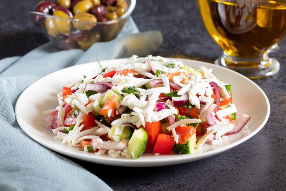 Salata bulgareasca cu legume si branza in farfurie alba