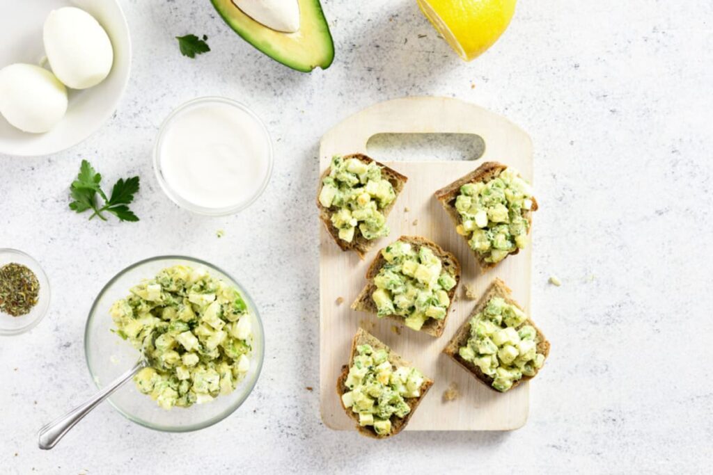Salata de oua cu avocado in bol si servita pe felii de paine