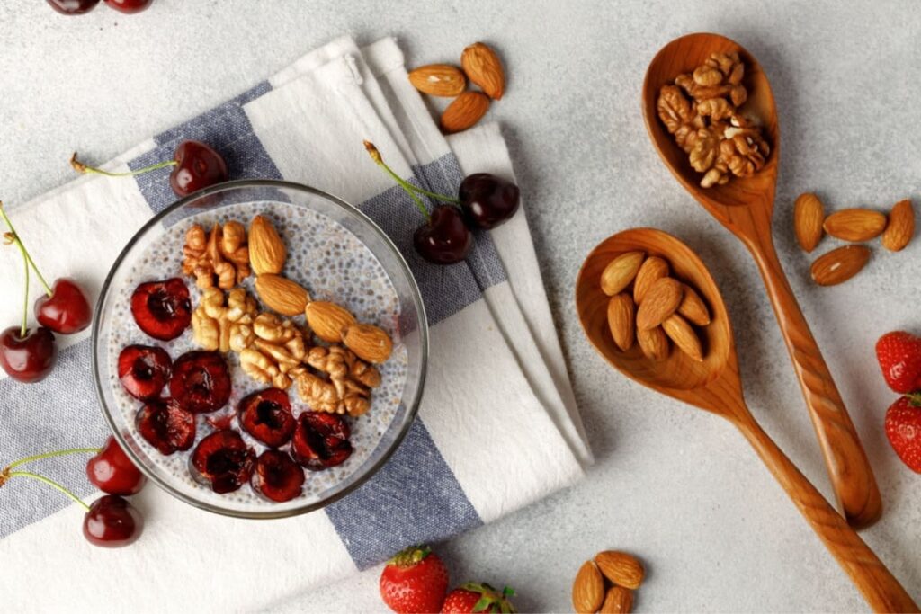 Bol cu budinca de chia, cirese, nuci si migdale pe servet de bucatarie