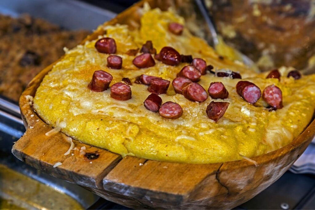 Bulz la cuptor cu branza si carnati in castron rustic din lemn