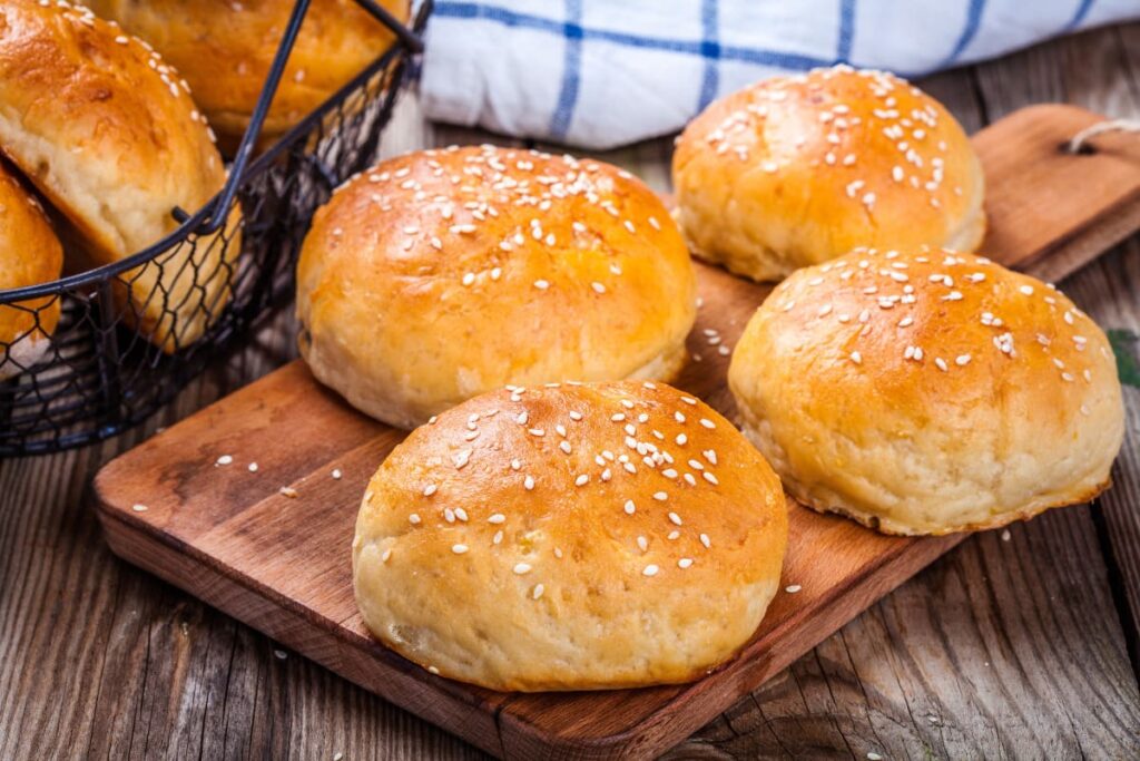 Chifle de burger facute in casa pe tocator din lemn