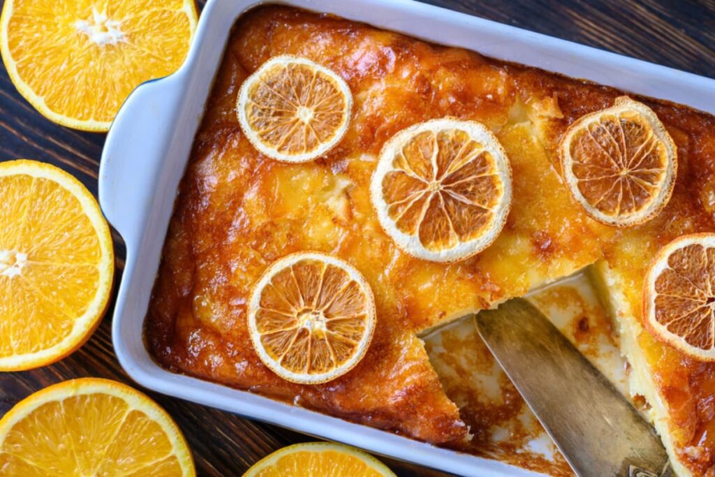 Prajitura greceasca cu portocale in tava de copt cu felii de portocala pe deasupra