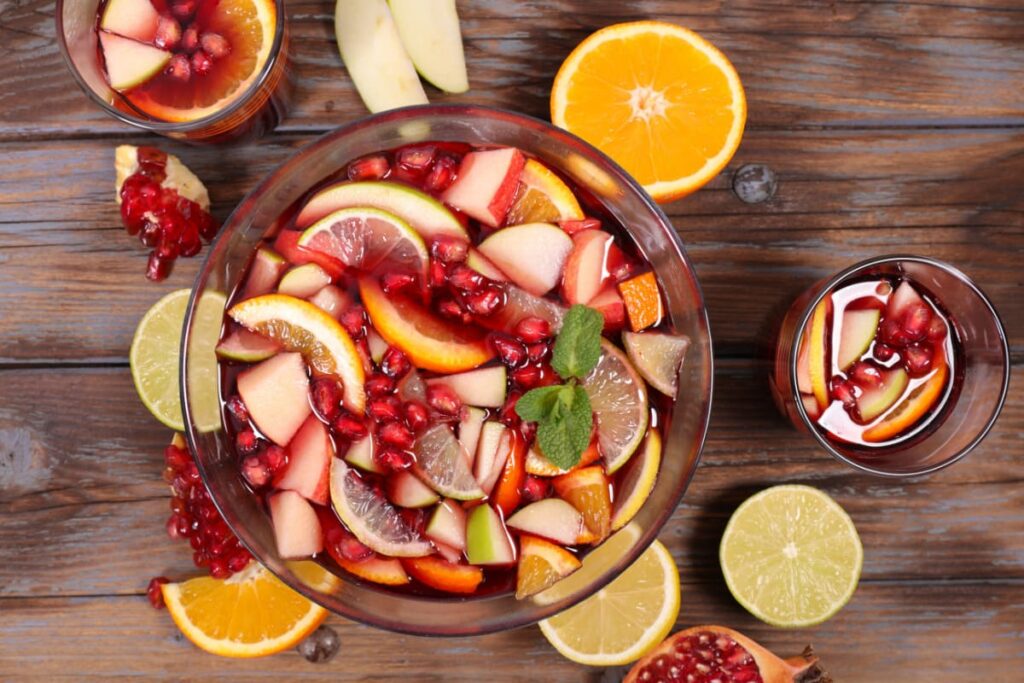 Cocktail sangria cu fructe in vas din sticla pe masa rustica