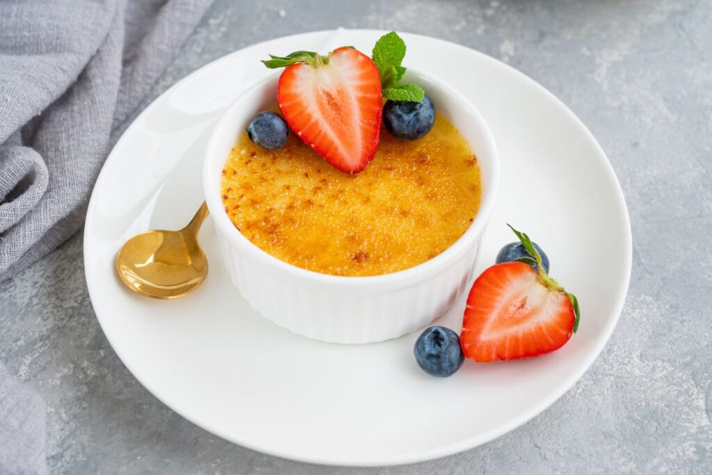 Creme brulee in bol alb cu afine si capsuni