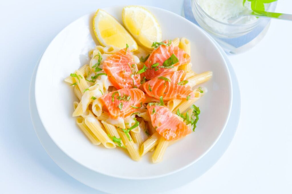 Paste cu somon afumat si sos alb in farfurie adanca alba