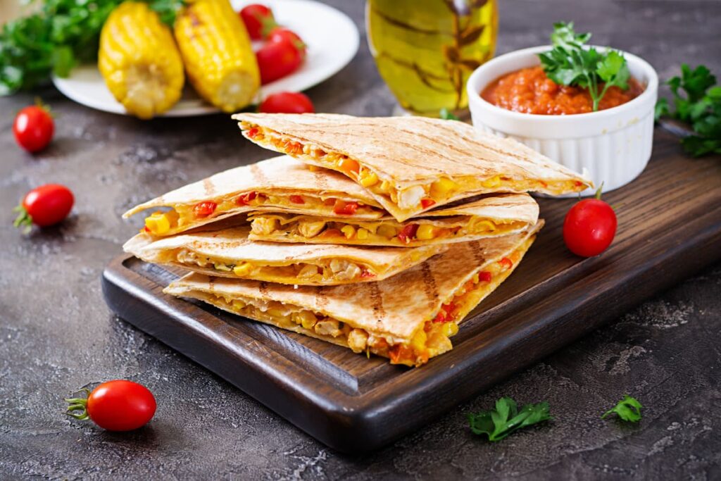 Quesadilla cu legume si branza pe tocator din lemn