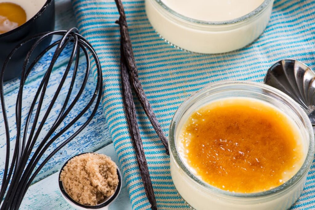 bol cu creme brulee langa zahar, ou, pastai de vanilie si smantana lichida