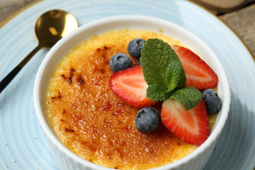 creme brulee in forma ceramica decorata cu afine, capsuni si frunze de menta