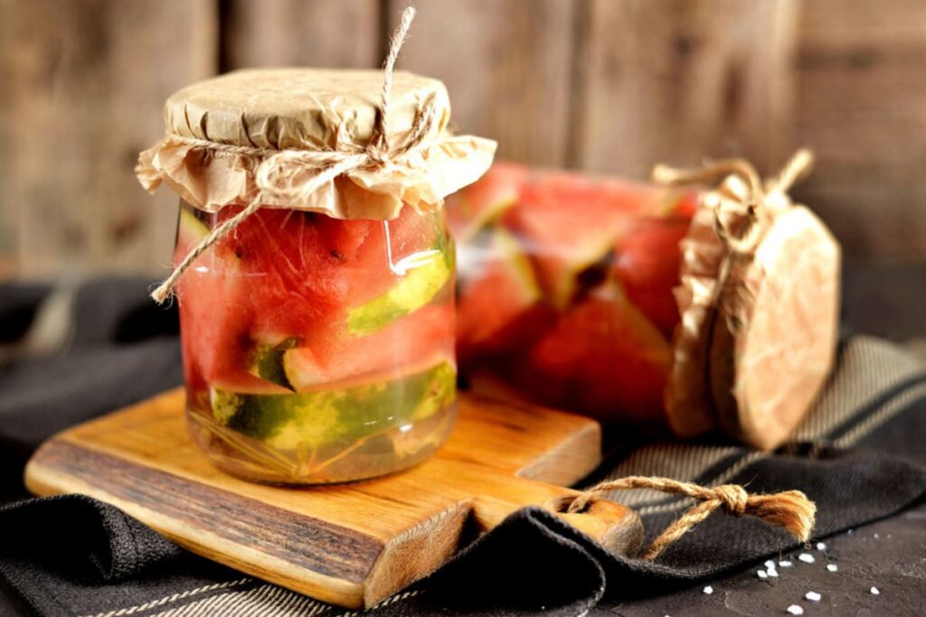 borcane cu pepeni murati in saramura pe masa rustica