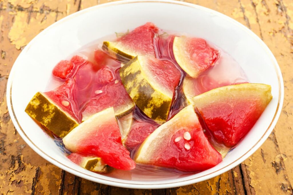 bucari de pepene murat in bol alb pe masa din lemn