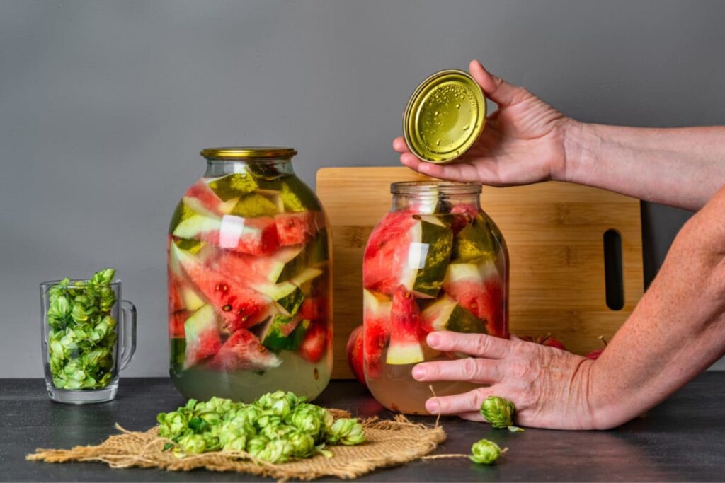 femeie care infileteaza borcane cu pepeni murati